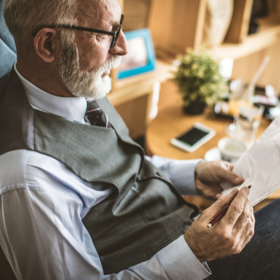 Elderly man  in a suit reading a will
