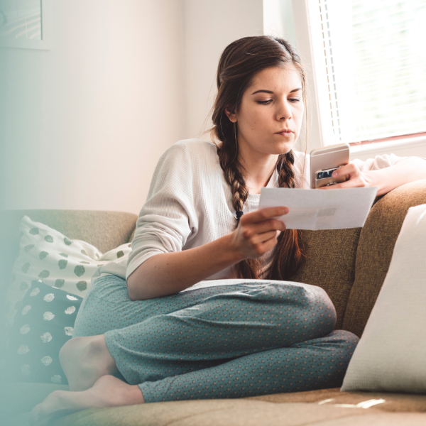 Young woman sorting out bills on her phone