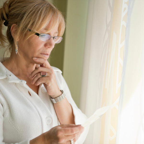 middle aged woman looking at a utility bill