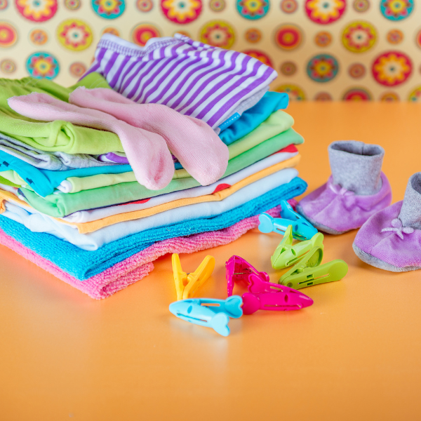 Baby clothes, socks and shoes on an orange background