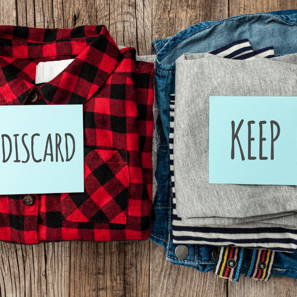 Two piles of clothes one labeled Discard and one Keep