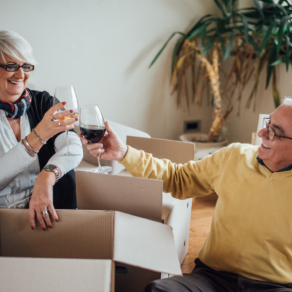 Elderly couple drinking wine after retiring and moving house