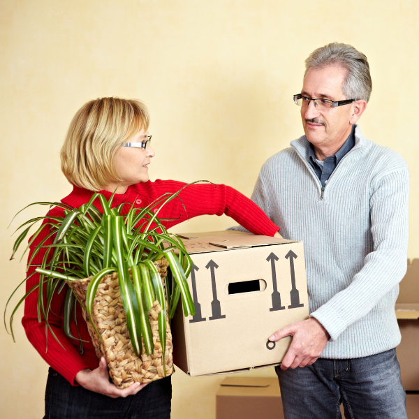 older couple moving boxes into storage