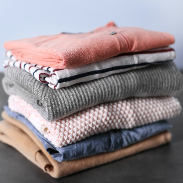 knitted tops and jumpers folded in a pile
