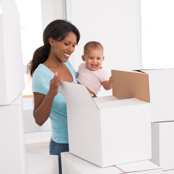 A baby and mother looking at cardboard boxes to put into storage