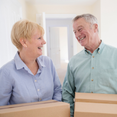 Happy retired couple moving boxes