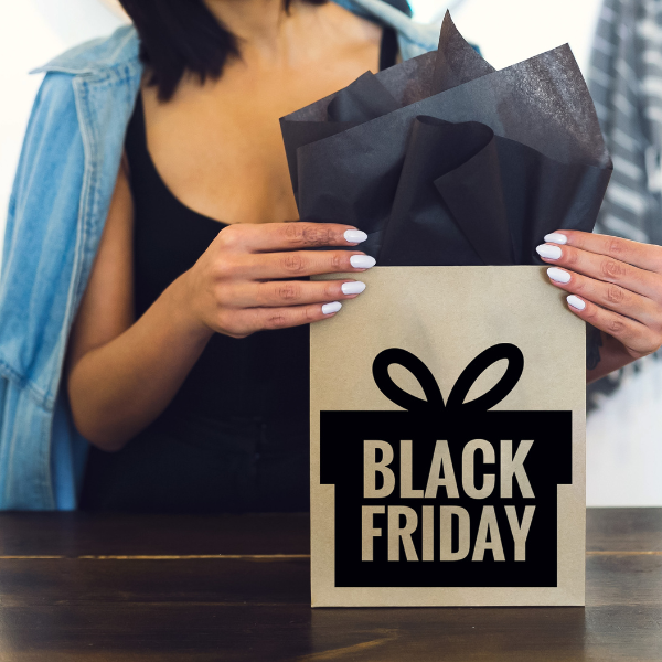 Woman opening cardboard gift saying Black Friday