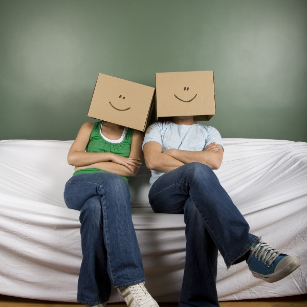 A couple with smiley cardboard boxes on their head after moving house