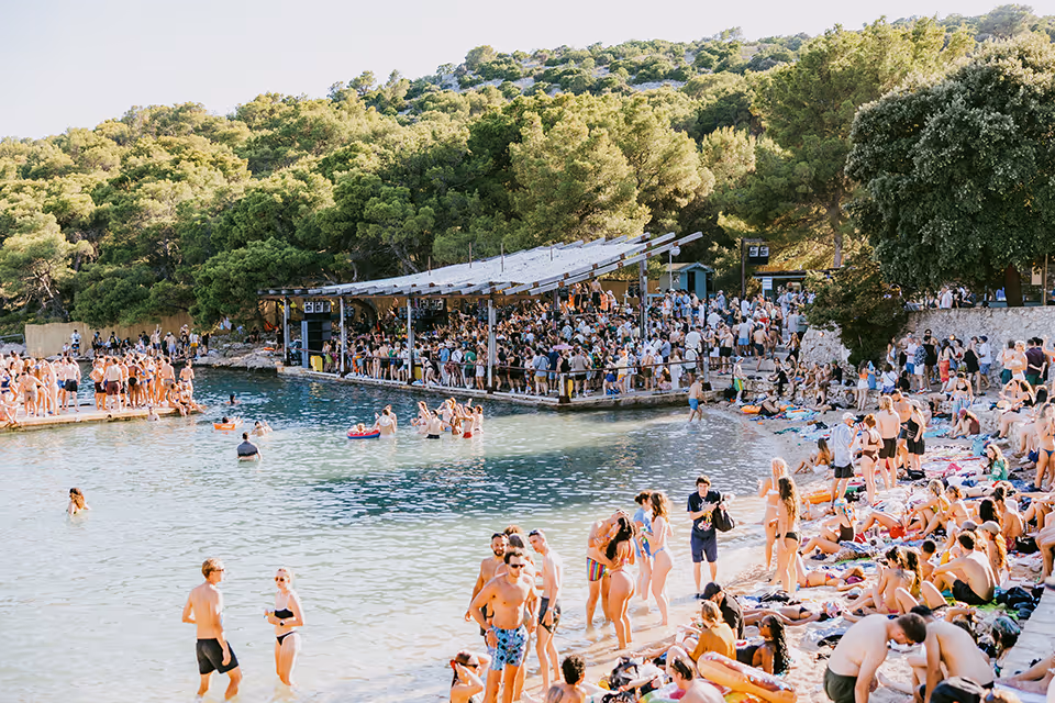 An image of people sunbathing near the beach stage at Love International Festival.