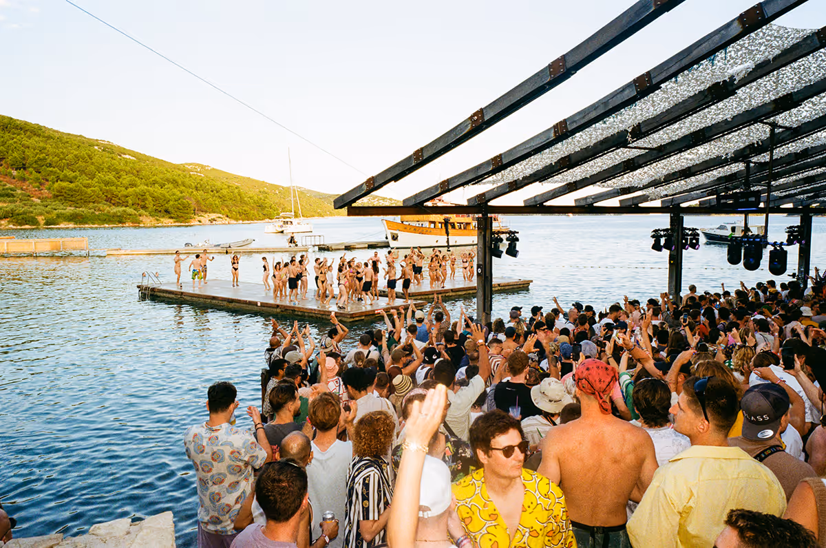 An image of people dancing near the water's edge at Love International Festival