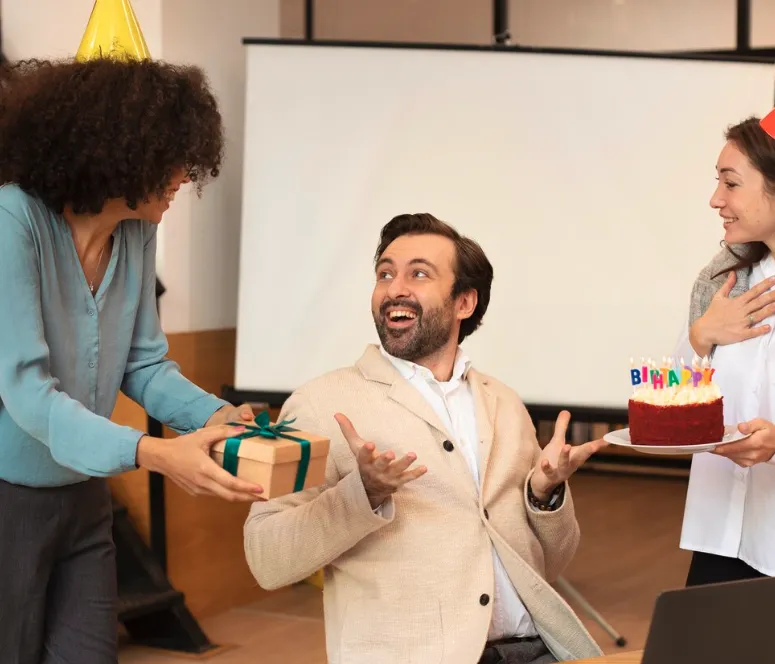 trois personne offre un cadeau à son collaborateur