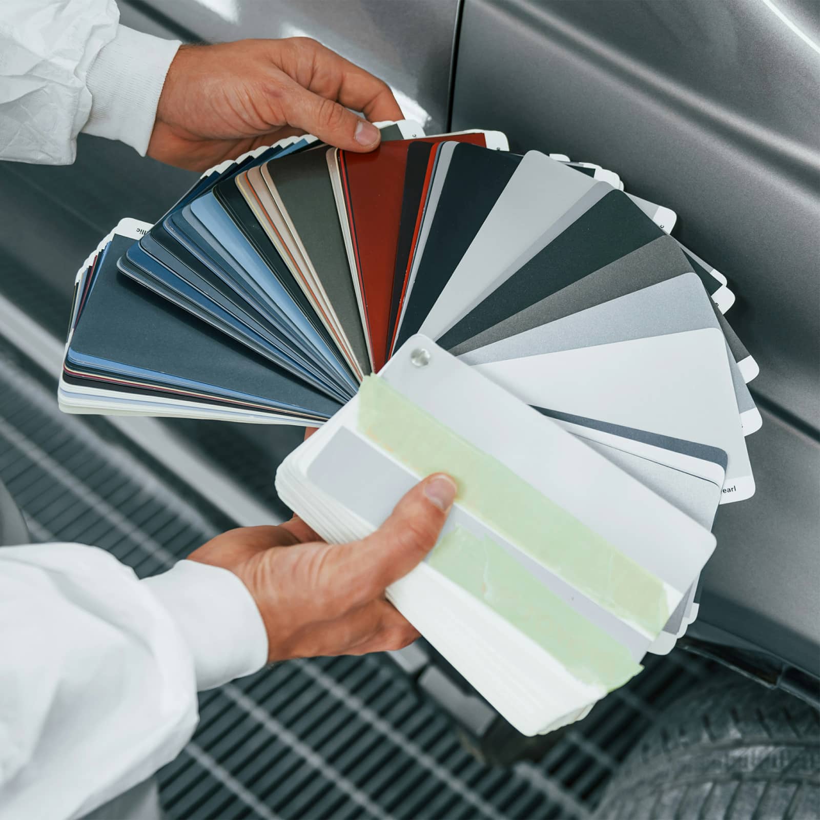 An employee holding a fanned out paint swatch booklet