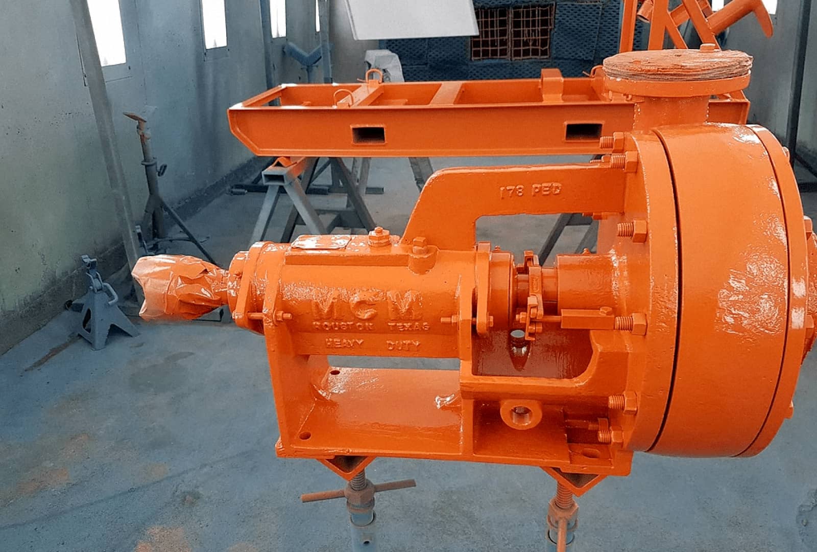 Newly painted bright orange metal part in the warehouse