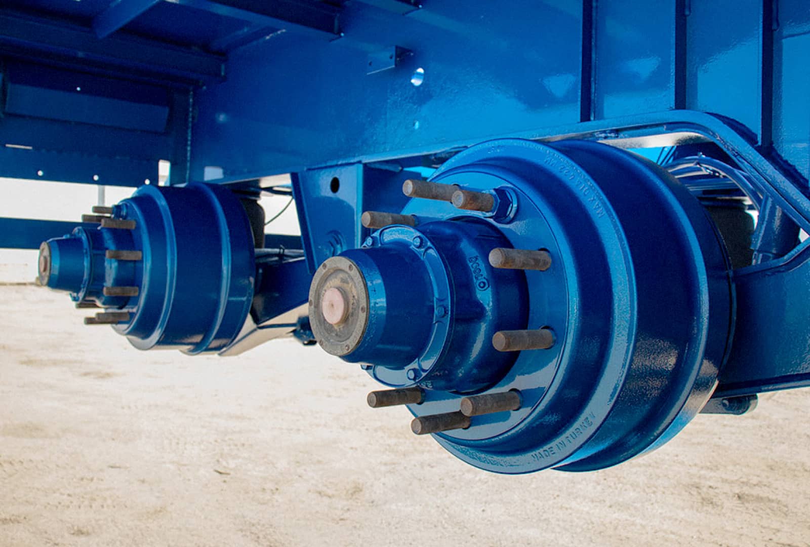 A brightly coloured blue metal part under a truck