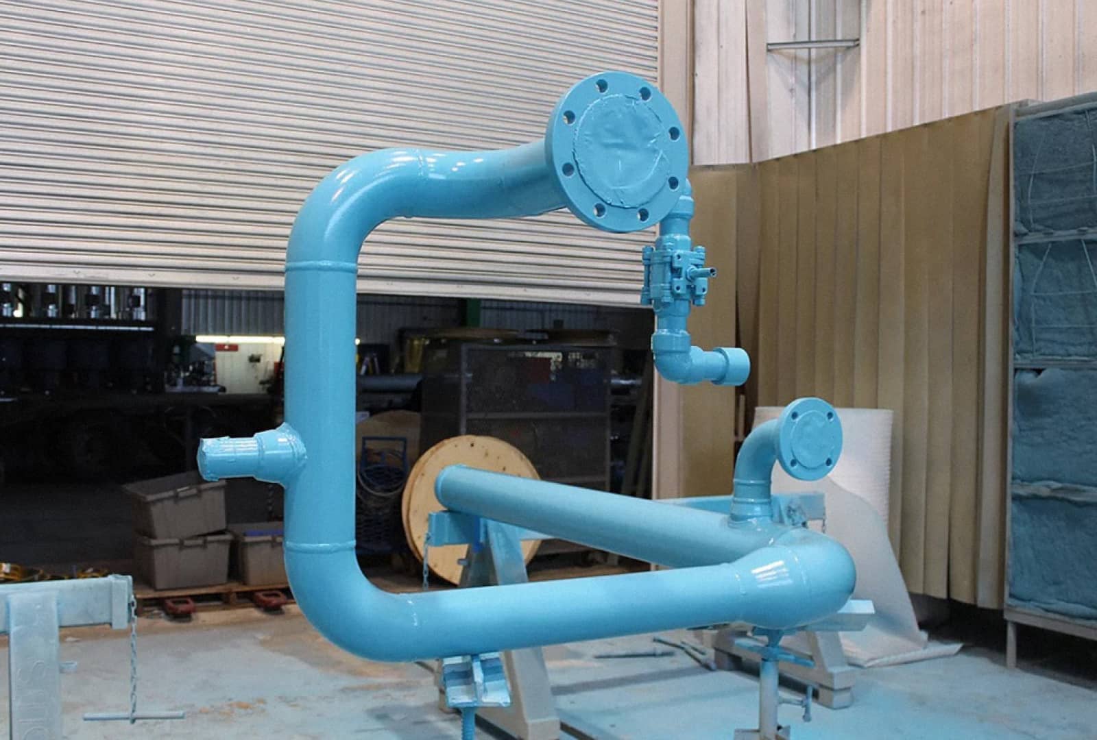 A newly painted light blue metal part in a warehouse