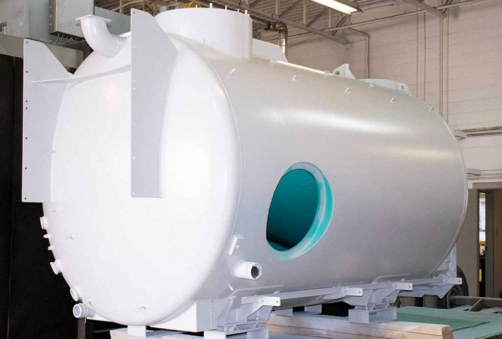 A newly painted bright white cylindrical tank with teal interior