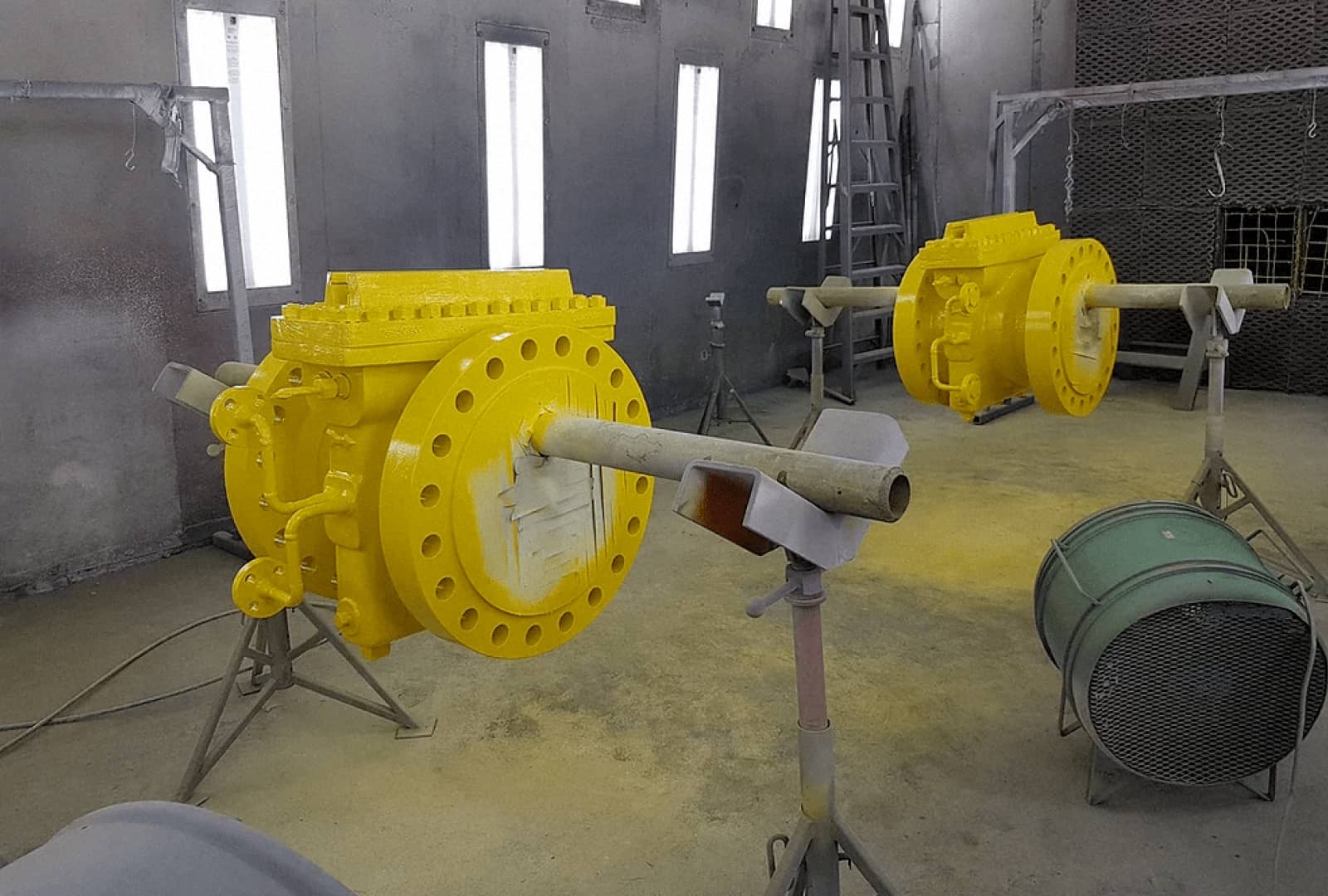 Two newly painted bright yellow truck parts in a warehouse
