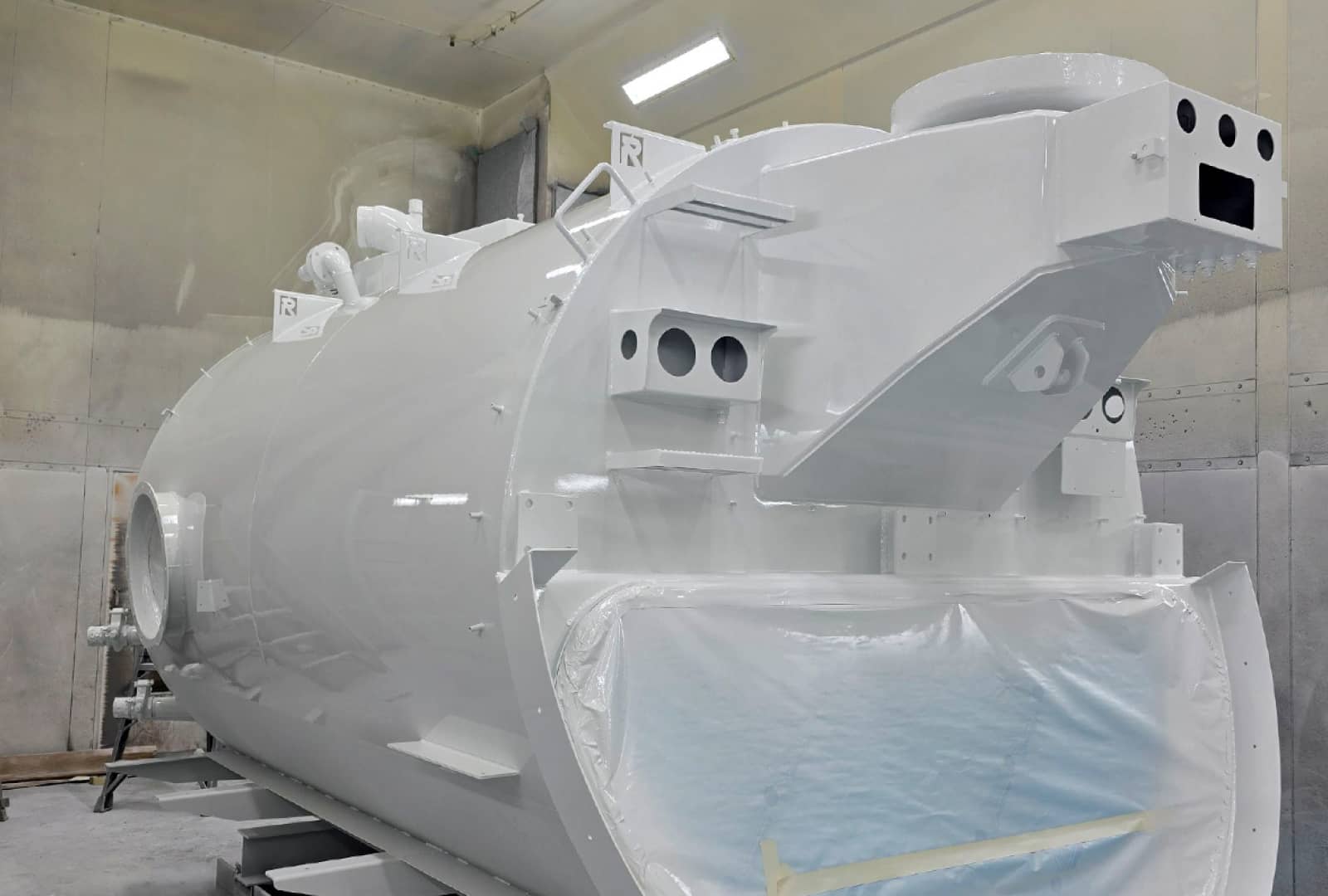 A newly painted full white tank in the painting facility