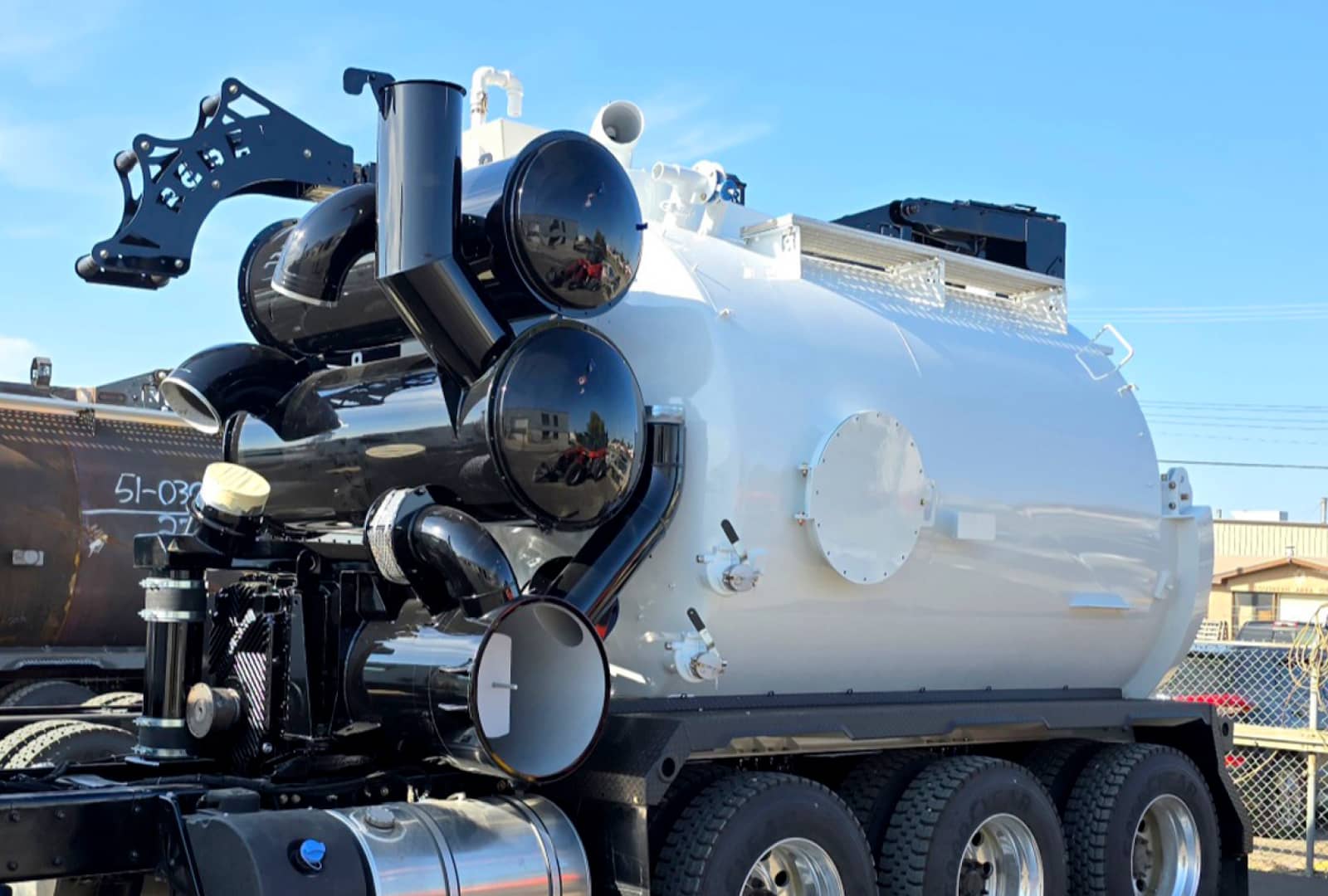 Large, white hydrovac truck freshly painted with black finishes