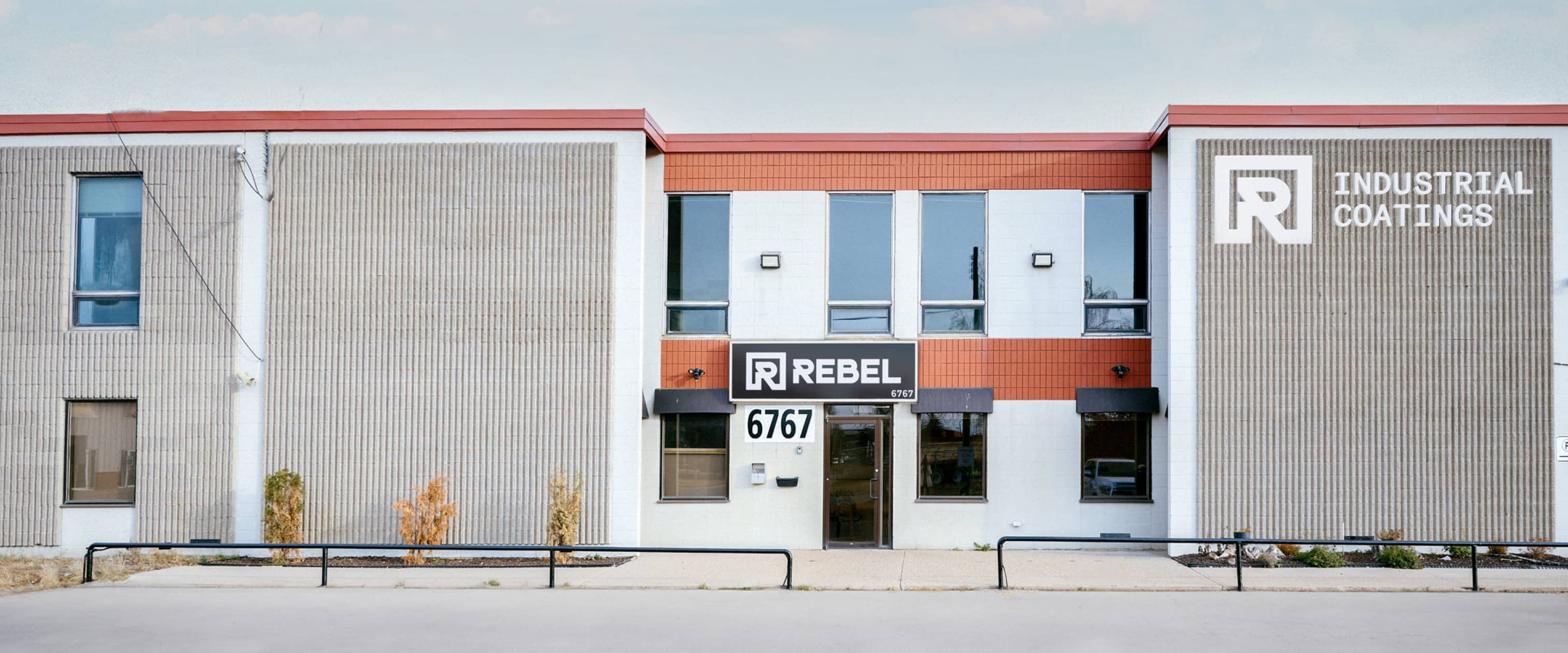 Rebel Industrial Coatings building, a central door, flanking windows, and logo on wall