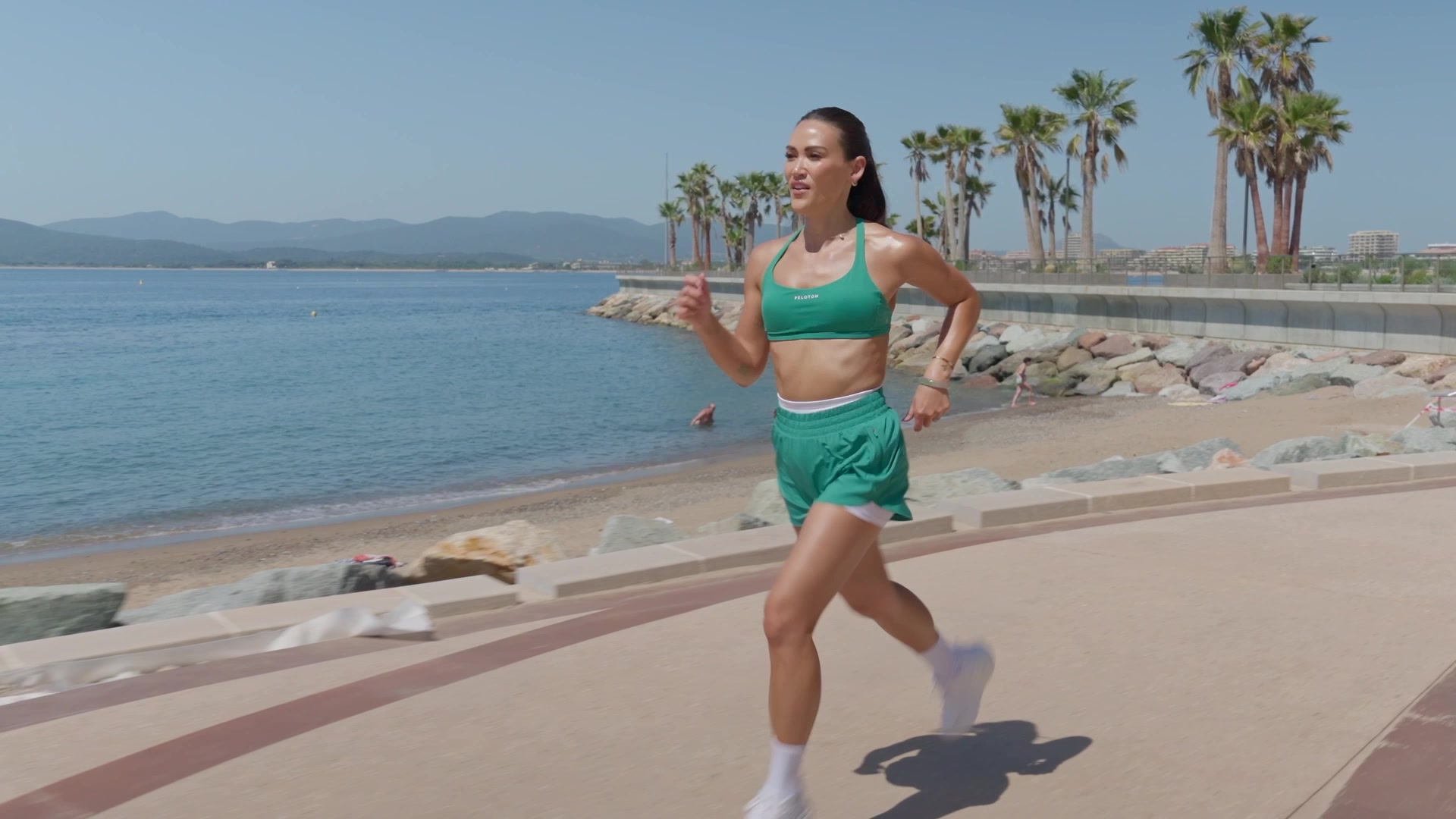 Coach Peloton courant sur la promenade du front de mer, tournage fitness sur la Côte d'Azur