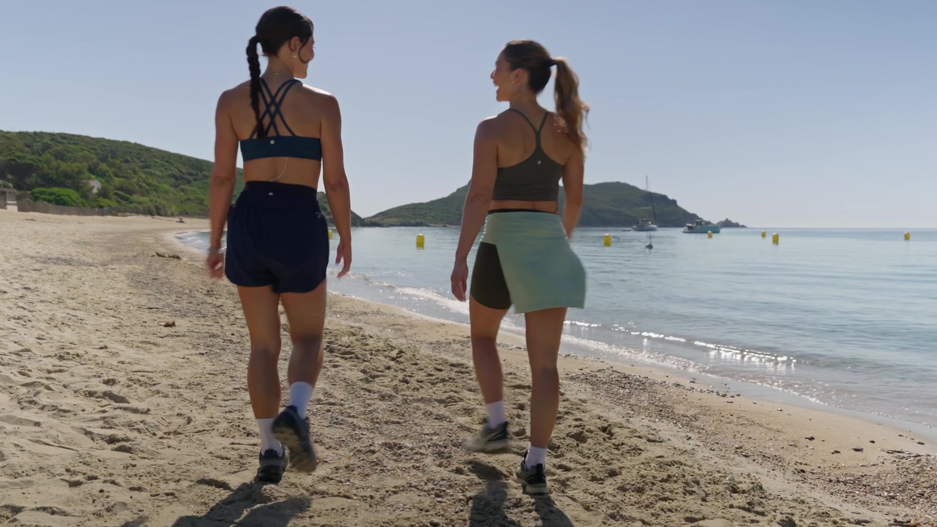 Deux coachs Peloton marchant sur une plage de la Côte d'Azur, tournage French Riviera Series