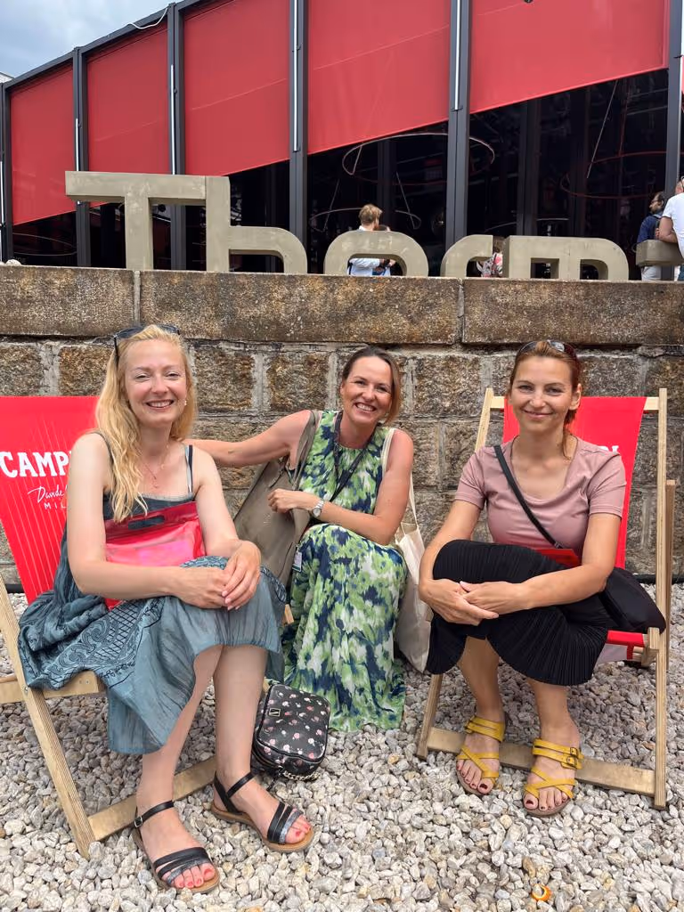 Ženy sedící na pláži na plážových židličkách.