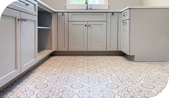 Modern kitchen with decorative patterned floor tiles and white cabinetry, highlighting stylish interior tile applications.