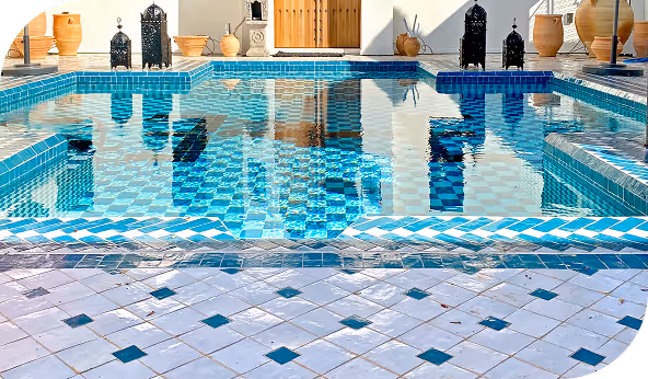 Luxurious swimming pool with intricate blue and white tile design, surrounded by decorative lanterns and pottery, showcasing premium craftsmanship for general contractors.