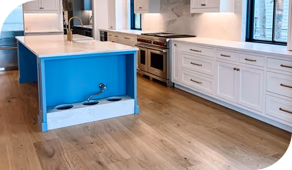 Modern kitchen with restored wooden floor, white cabinets, and a blue kitchen island, showcasing a clean and updated design.