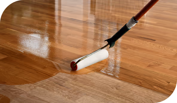 Applying a glossy finish to a hardwood floor with a roller, highlighting available finish options.