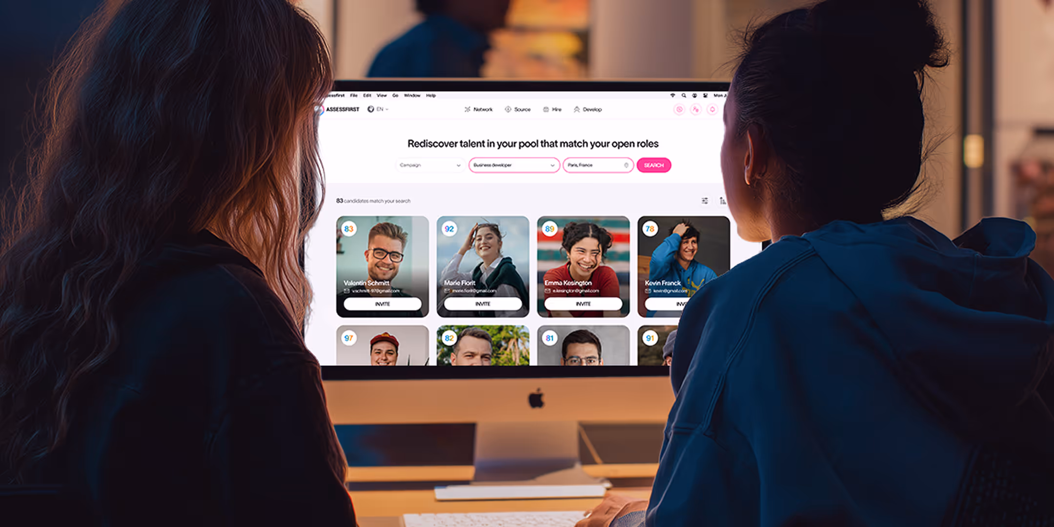 two people sitting in front of a computer viewing the AssessFirst platform interface displaying candidate profiles for a business developer role