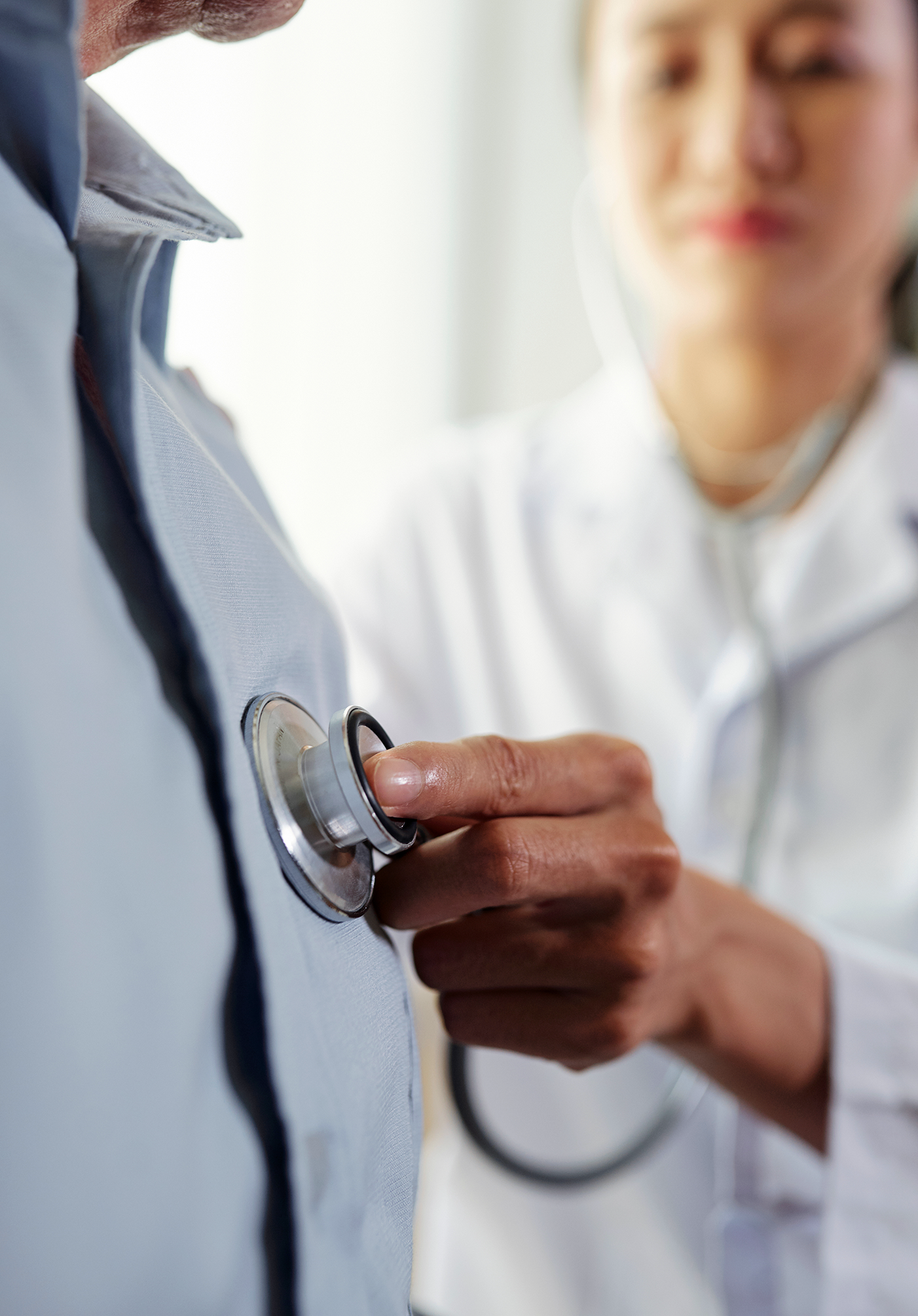 Close-up of a healthcare professional using a stethoscope to listen to a patient's chest.