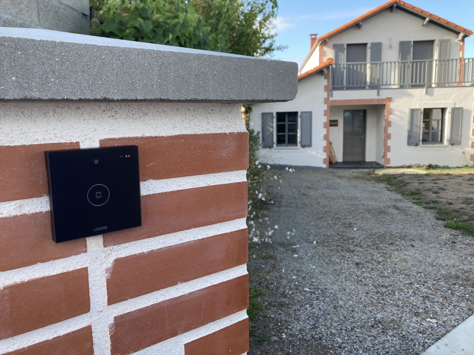 Portier vidéo Loxone Intercom installé sur un pilier en brique à l'entrée d'une maison à La Crèche (79)