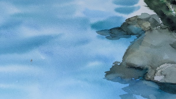 Watercolor of grey-green rocks layered in translucent washes along the right edge, meeting soft, overlapping bands of blue water. Quiet, light, and loosely abstract.