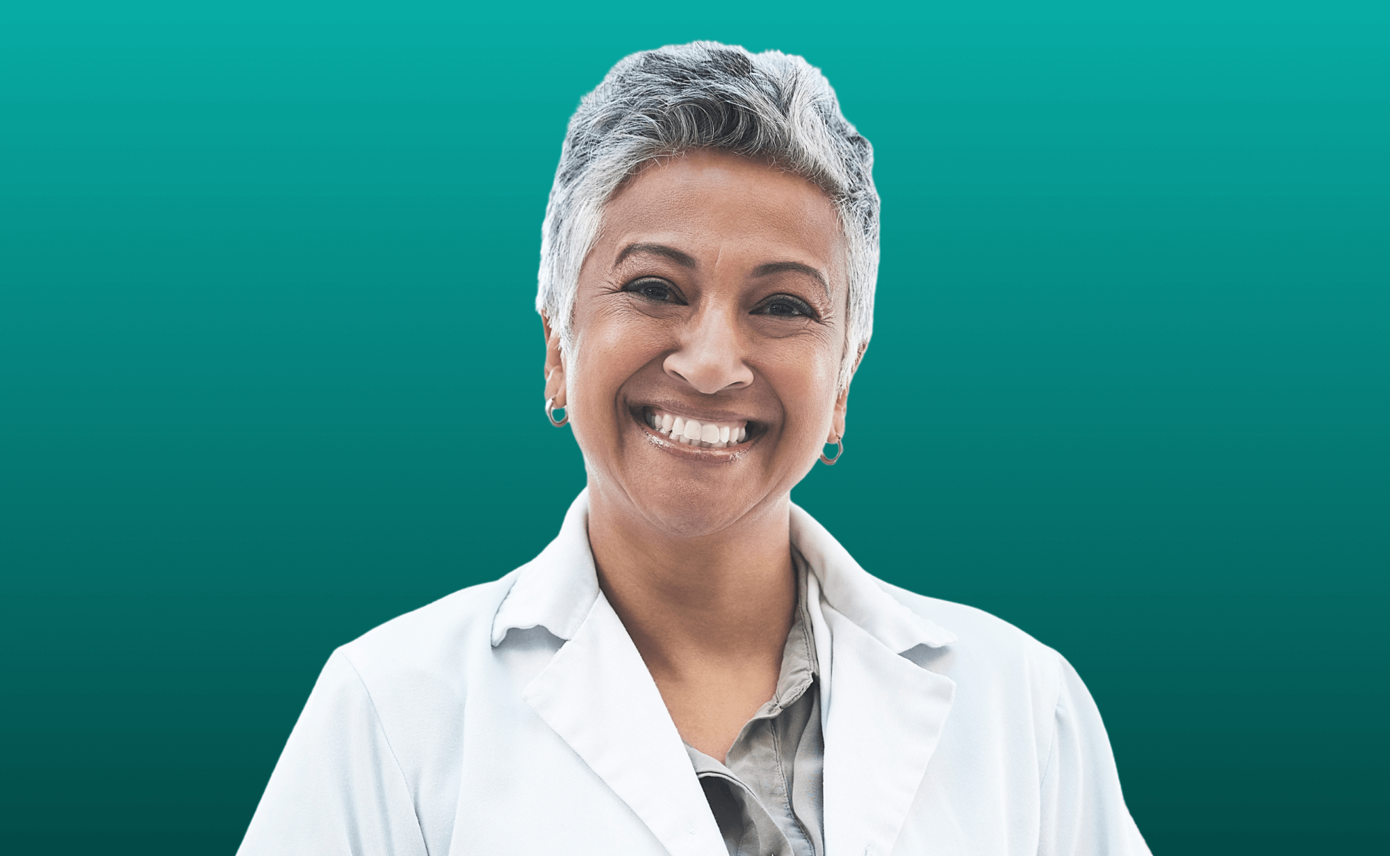 Smiling mature woman with short gray hair wearing a white lab coat against a teal background.