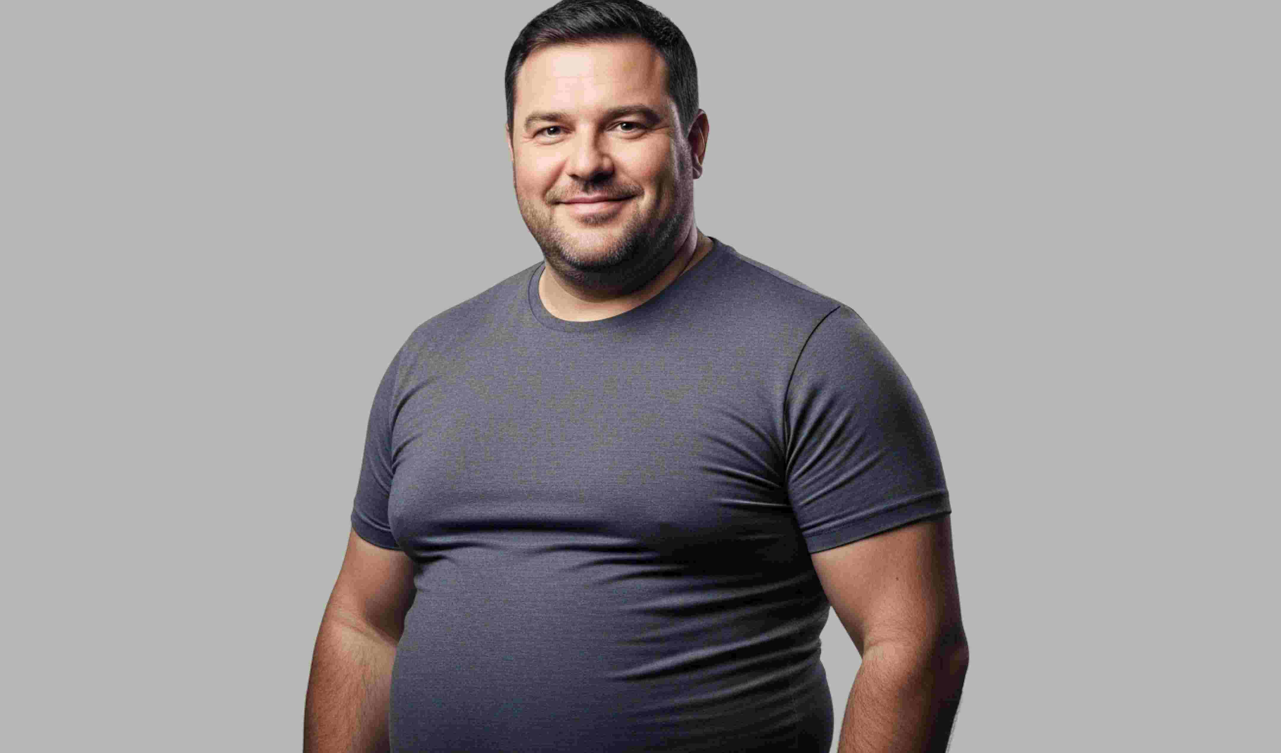 Smiling man with short dark hair wearing a fitted gray t-shirt standing against a plain gray background.