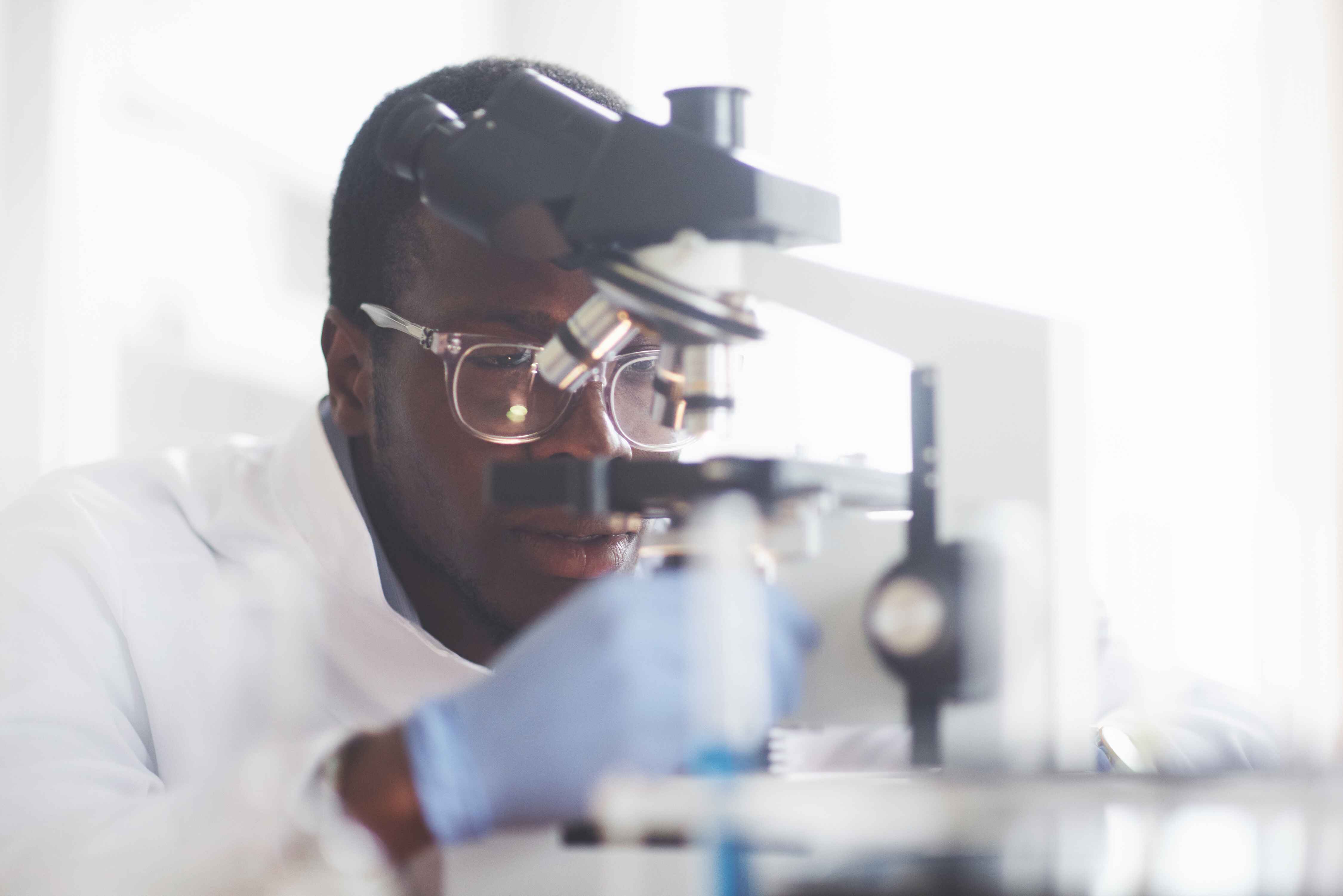 Scientifique travaillant avec un microscope pour l'innovation pharmaceutique