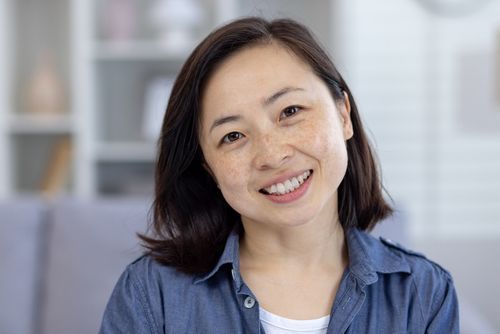 Smiling woman standing in a bright room at home