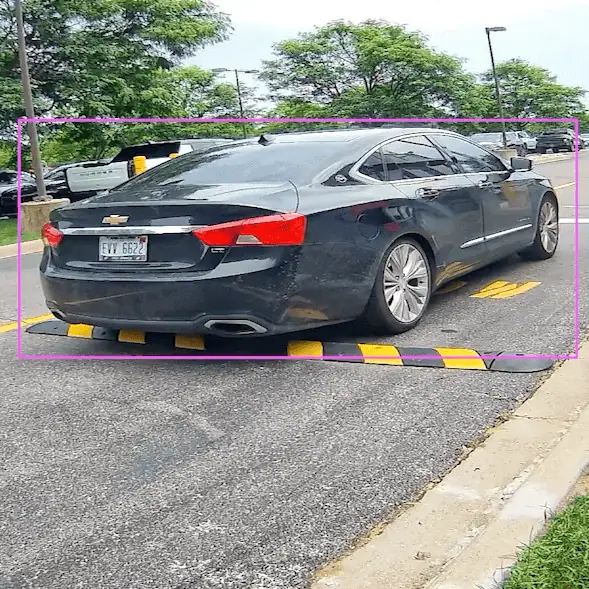 Gate camera view of a sedan at a speed bump with a detection box around the car and its rear license plate