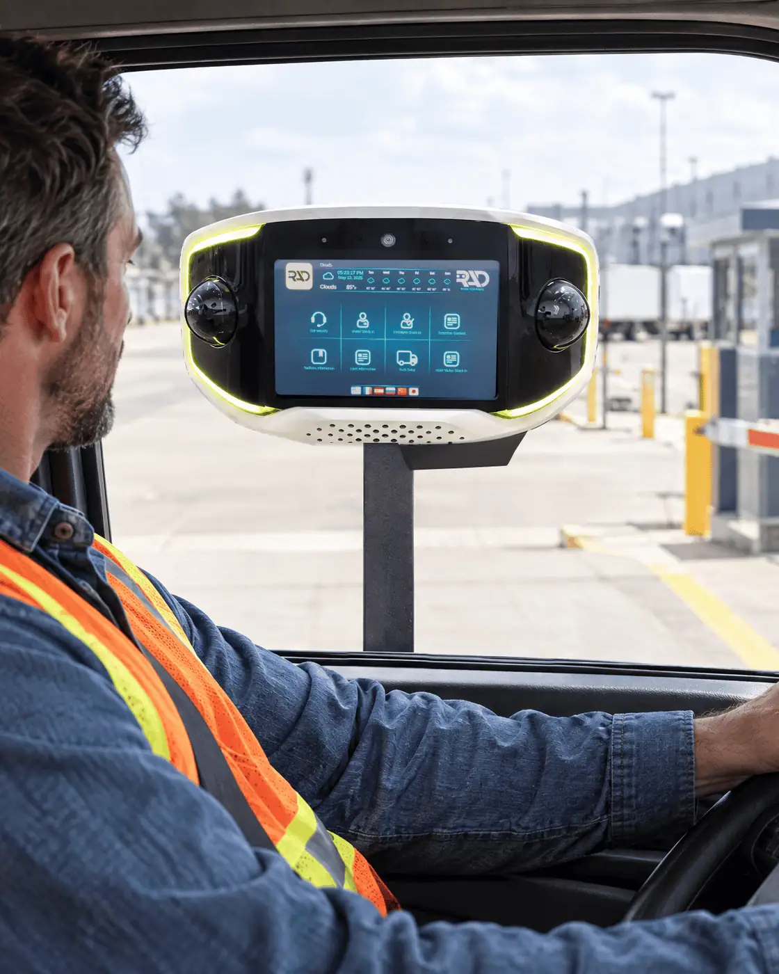 Driver in a semi cab checking in at a distribution centre gate with AVA on a black pedestal at the window
