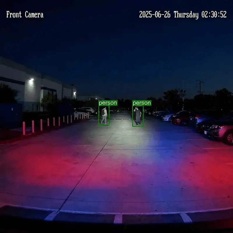 ROAMEO front-camera view of a parking lot at night with two people inside detection boxes labeled person