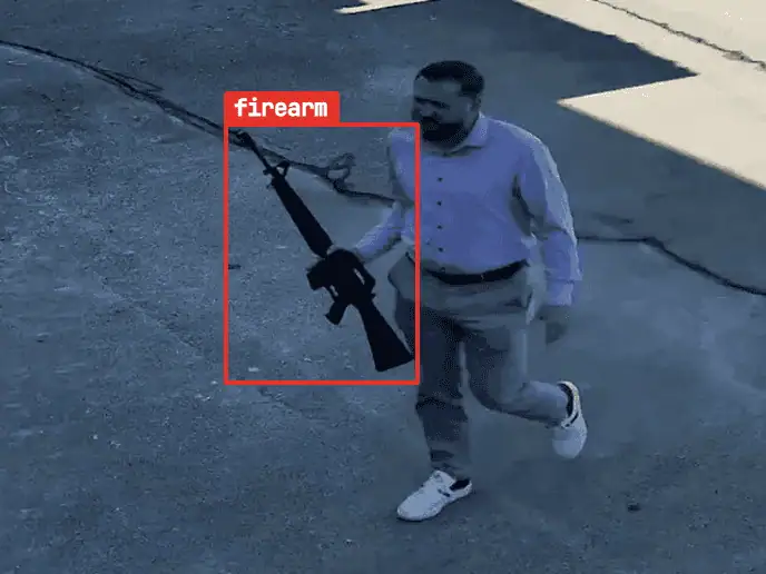 Staged test frame of a person carrying a rifle, the rifle flagged in red