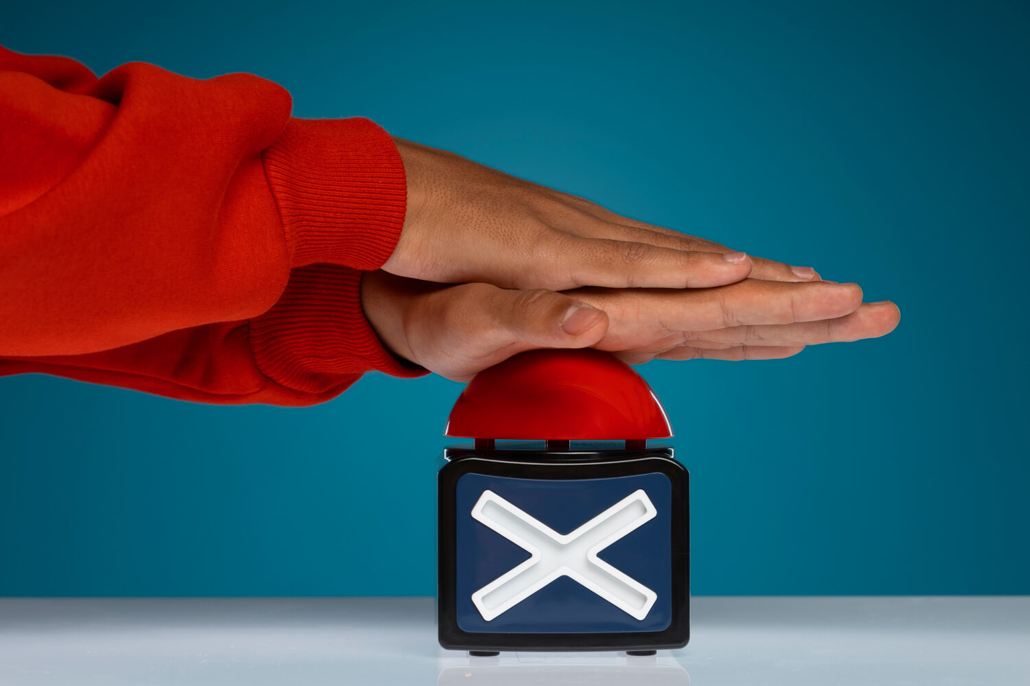 Mano apretando un botón rojo