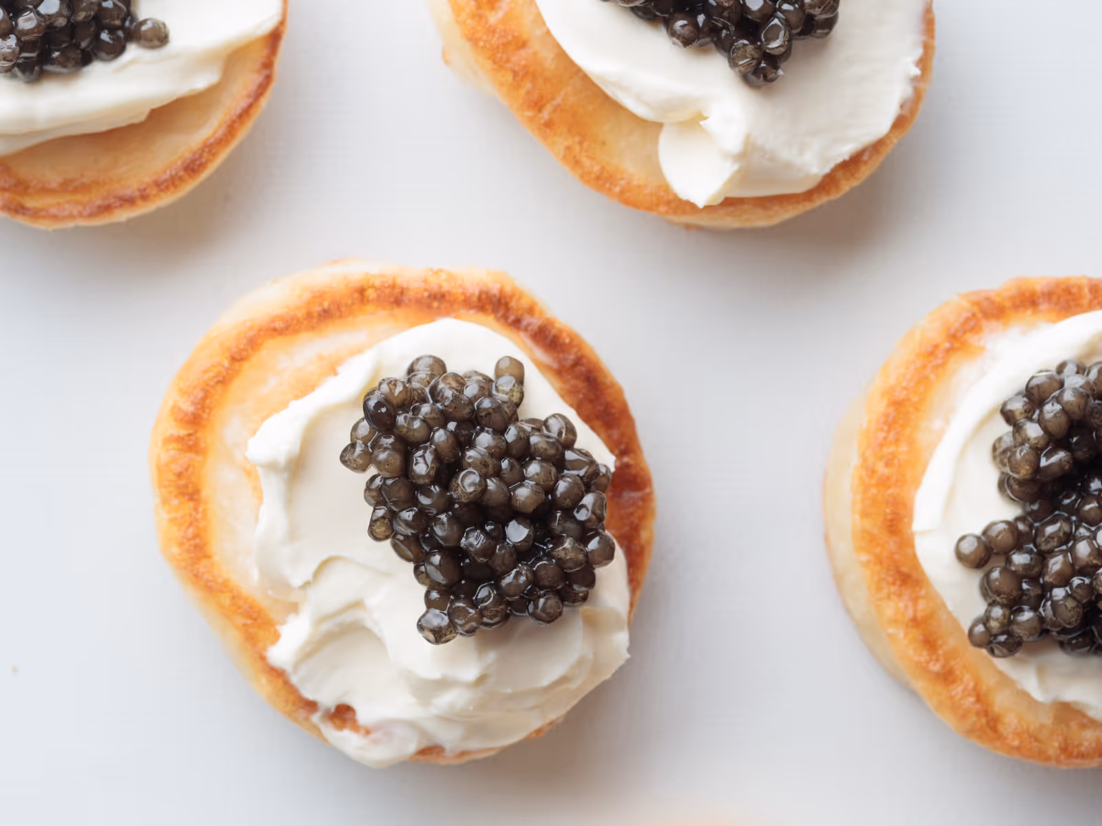 Fluffy pancakes topped with cream cheese and black caviar