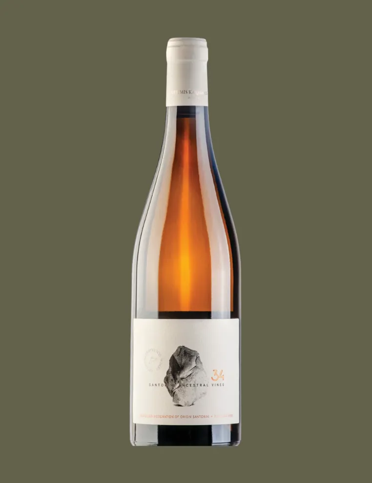 Bottle of Santorini Ancestral Vines wine with a white label featuring a rock illustration and the number 34.