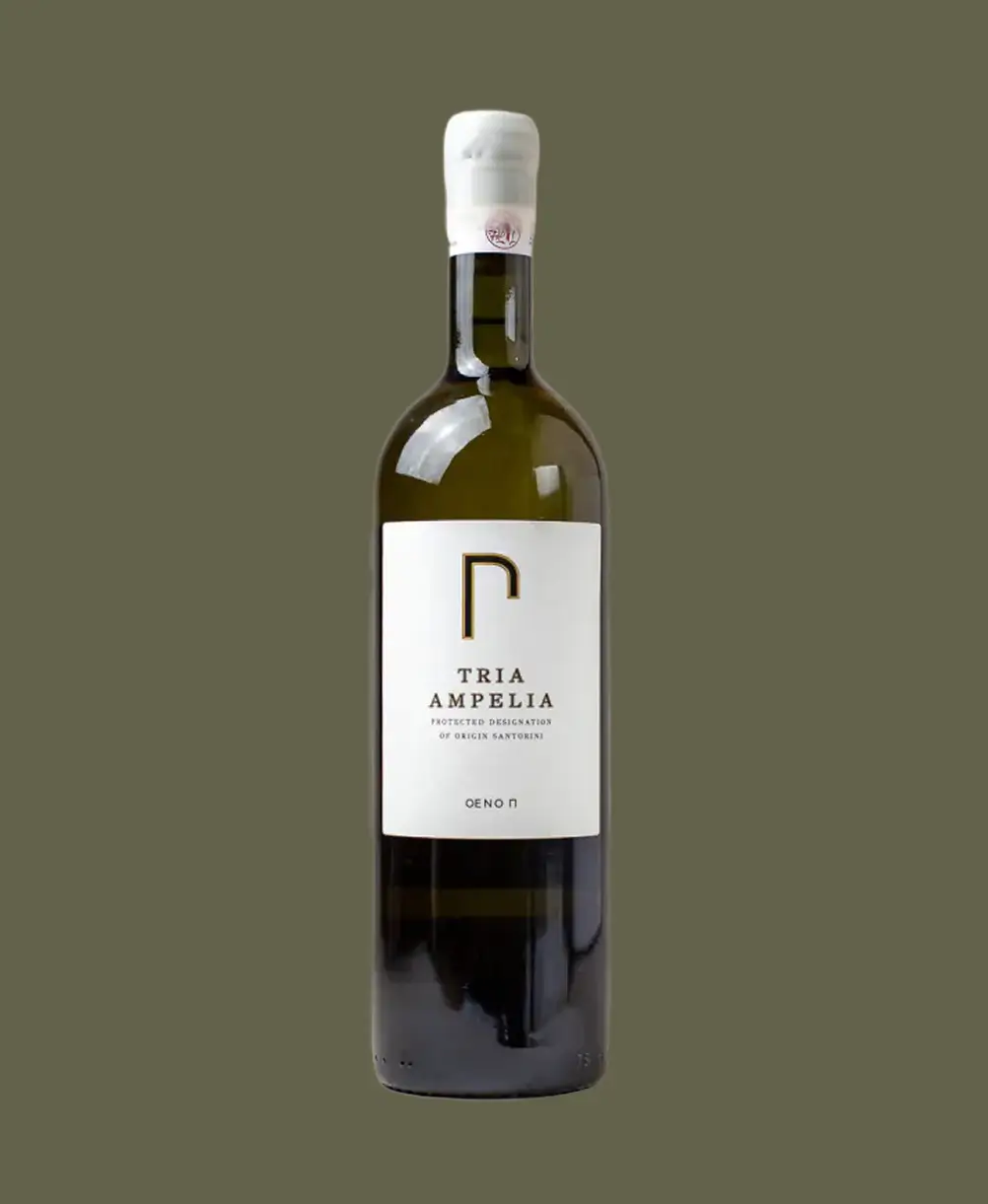 Bottle of Tria Ampelia Greek wine with white label and sealed white cap on olive green background.