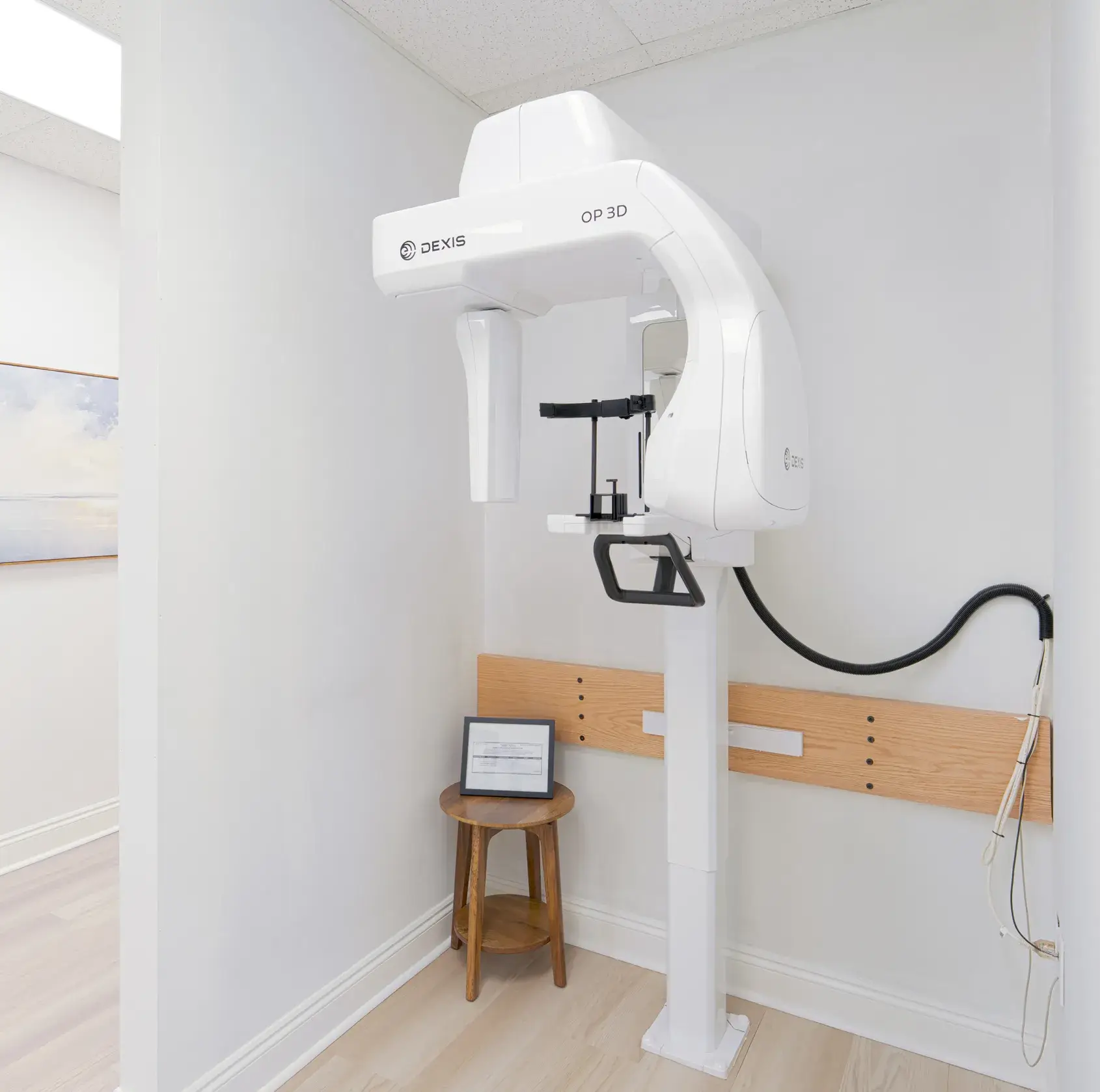 Dexis OP 3D dental X-ray machine mounted on a wall in a clean, bright room.