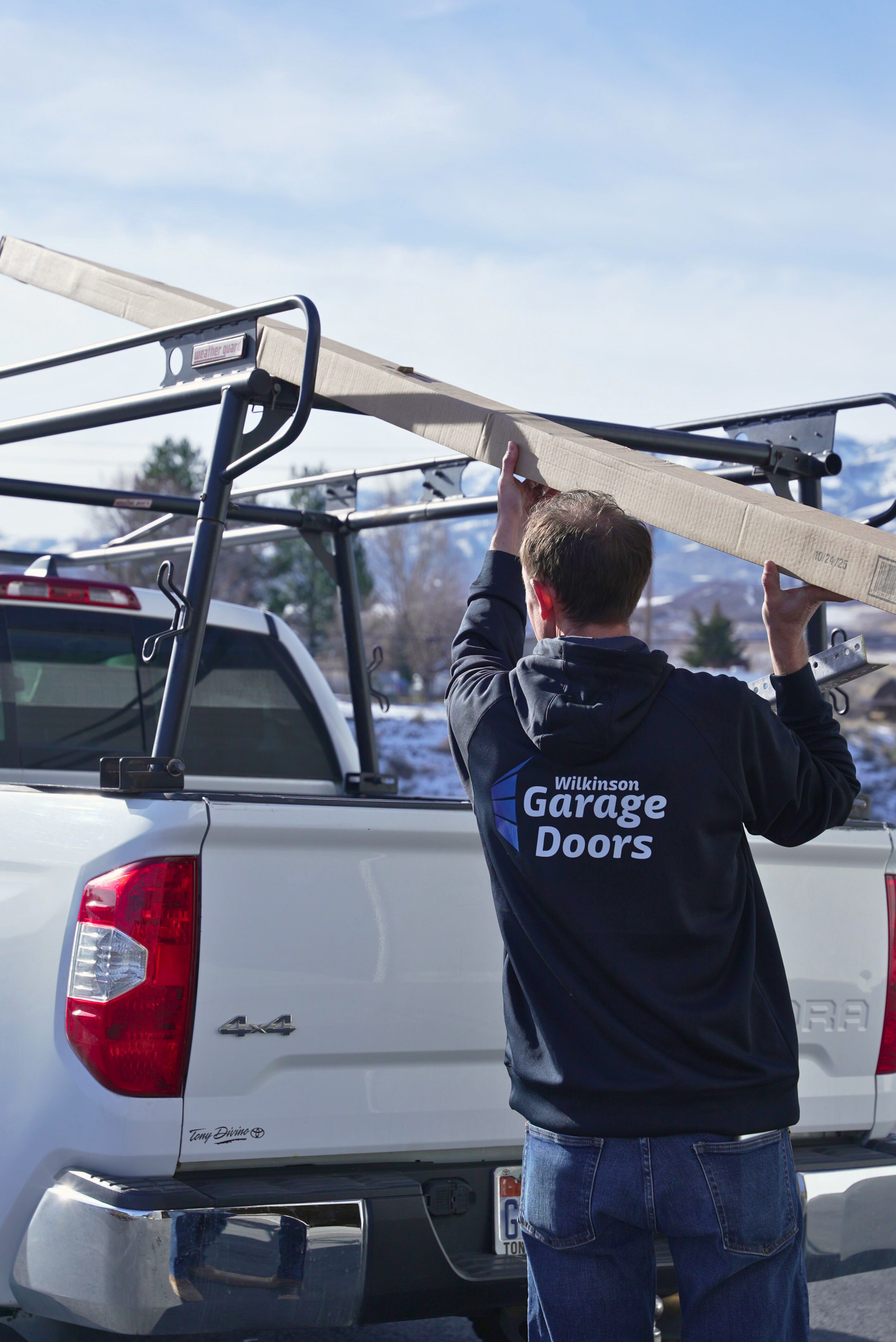 Wilkinson Garage Doors technician loading door panels onto truck Morgan County Utah