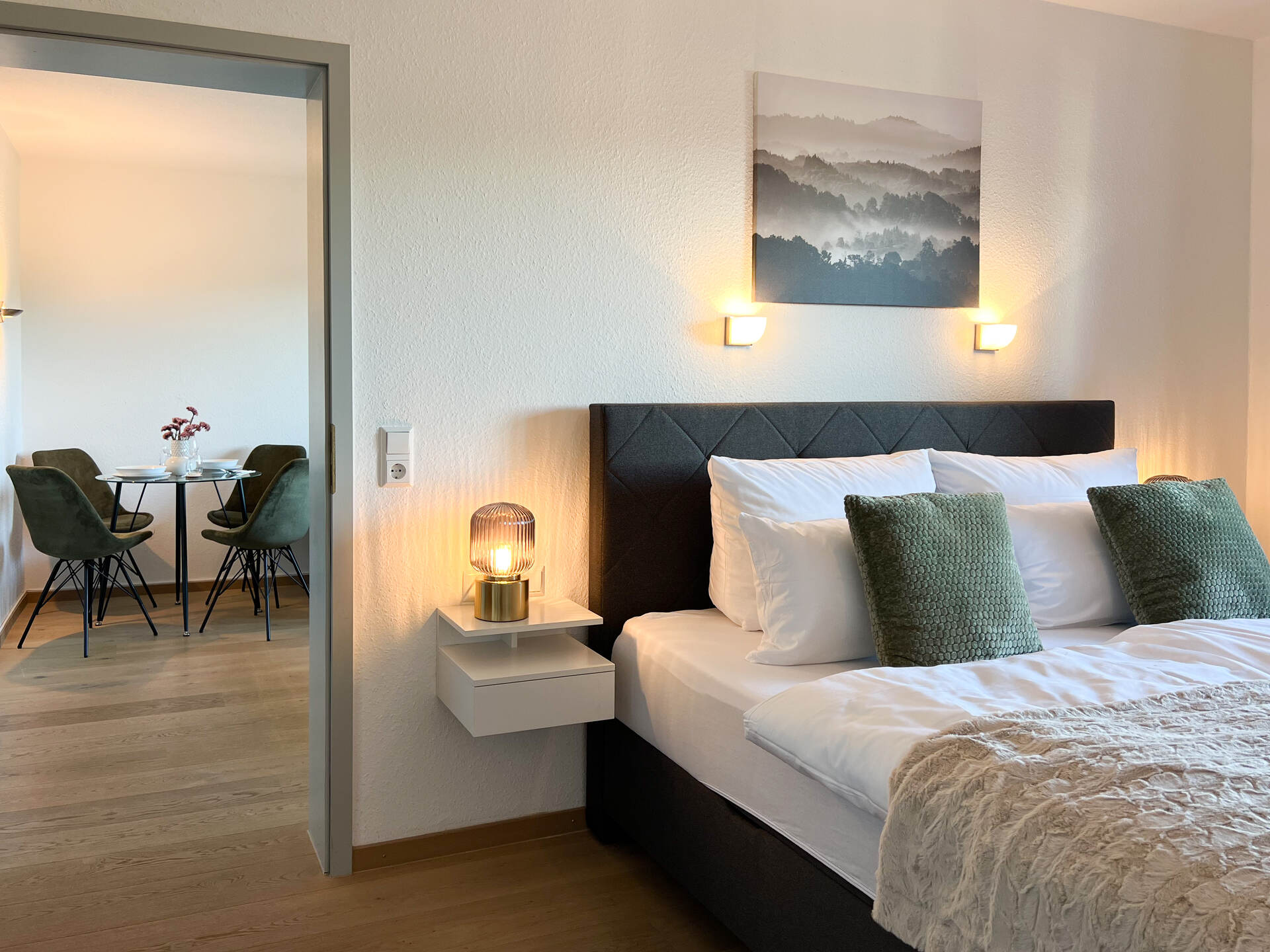 Schlafzimmer mit Boxspring Doppelbett und Blick ins Wohnzimmer